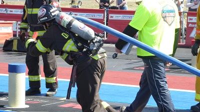 Blue Team Firefighter Continues Forward with Hose